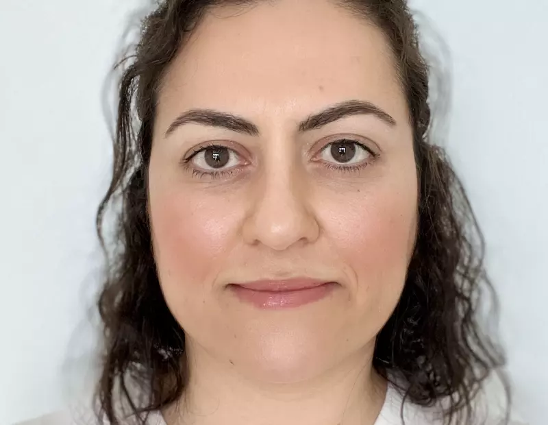 Dr Fuyla Taylan has shoulder length brown hair and brown eyes. She is smiling.  